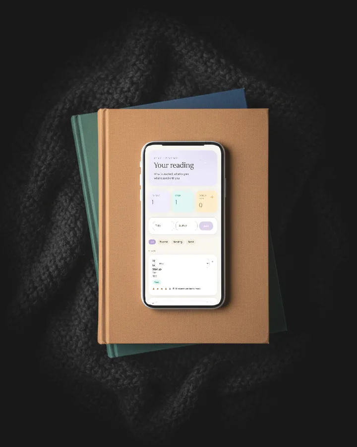 The Reading List app on a phone laid on a stack of cloth hardbacks, photographed from above.